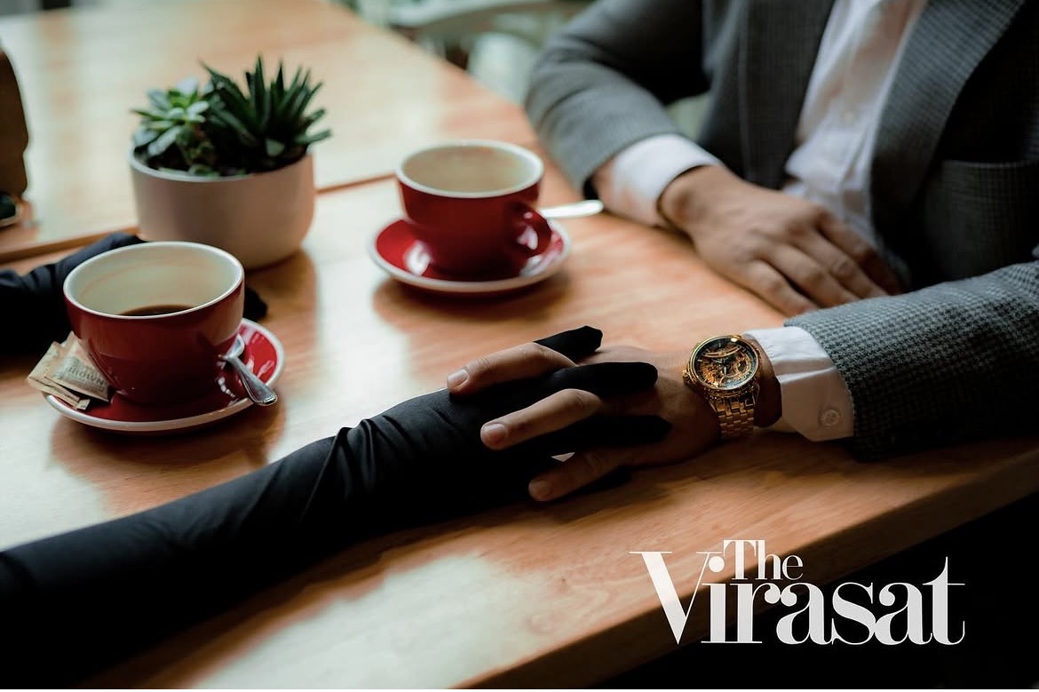 A couple holding hands across a café table